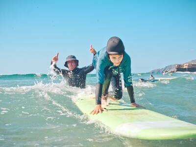 family surf instructor Derek is in the water with the kids