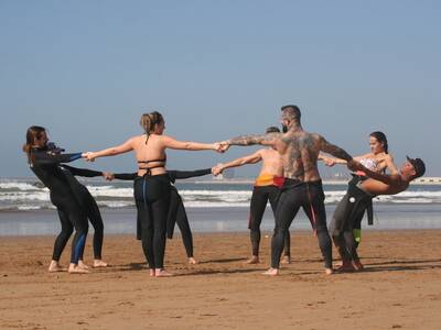 Group warming up on Agadir beach with Original Surf Morocco