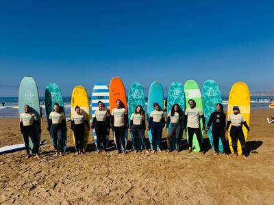 surf students standing with colorful surfboards on a beach in tamraght